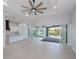 Spacious open-plan living area with sliding doors to outdoor patio and pool, modern ceiling fan at 14526 Fort Worth Cir, Port Charlotte, FL 33981