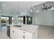 Open floor plan with kitchen island, tile flooring, and access to outdoor living area at 14526 Fort Worth Cir, Port Charlotte, FL 33981