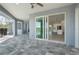Elegant outdoor patio with stone flooring, screened-in pool and seamless flow to the open-concept kitchen at 14526 Fort Worth Cir, Port Charlotte, FL 33981
