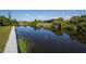 Picturesque waterfront with serene pond views, natural foliage, and a dock for enjoying the tranquility at 14526 Fort Worth Cir, Port Charlotte, FL 33981