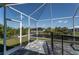 Screened patio with a serene view of the backyard, canal, and surrounding lush landscaping from the waterfront home at 14526 Fort Worth Cir, Port Charlotte, FL 33981