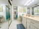Bright bathroom with double sinks, vanity area, and shower with updated fixtures at 149 Englewood Isles Pkwy # 609, Englewood, FL 34223