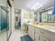 Bright bathroom with double sinks, vanity area, and shower with updated fixtures at 149 Englewood Isles Pkwy # 609, Englewood, FL 34223