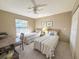 Bright bedroom features two twin beds, a ceiling fan, and a window with blinds at 149 Englewood Isles Pkwy # 609, Englewood, FL 34223