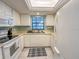 Kitchen with white cabinets, tiled floors and a window at 149 Englewood Isles Pkwy # 609, Englewood, FL 34223
