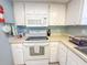 Kitchen with white cabinets, microwave and electric stove at 149 Englewood Isles Pkwy # 609, Englewood, FL 34223