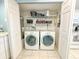 Laundry closet with full size washer and dryer and overhead storage shelves at 149 Englewood Isles Pkwy # 609, Englewood, FL 34223