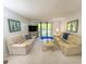 Spacious living room featuring comfortable sofas and a sliding glass door to balcony at 149 Englewood Isles Pkwy # 609, Englewood, FL 34223