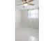 Clean bedroom with white walls, white tile floors, ceiling fan, and bright natural light at 1493 Kathleen Pl, Englewood, FL 34223