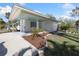 Charming home's exterior, featuring a covered porch with decorative columns and a beautifully landscaped garden at 1493 Kathleen Pl, Englewood, FL 34223