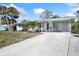 Beautiful home with a covered porch featuring decorative columns, ceiling fans, and a spacious driveway at 1493 Kathleen Pl, Englewood, FL 34223