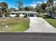 Charming single-story home with a long driveway and mature landscaping at 1493 Kathleen Pl, Englewood, FL 34223