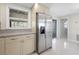 Bright kitchen featuring stainless steel refrigerator, granite countertops, and ample cabinet space at 1493 Kathleen Pl, Englewood, FL 34223