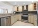 Well-lit kitchen showcasing stainless steel appliances, granite countertops, and gray subway tile backsplash at 1493 Kathleen Pl, Englewood, FL 34223