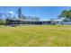 Expansive backyard featuring a screened pool area, a tiki bar, and a well-maintained lawn at 150 Crestview Dr, Englewood, FL 34223