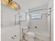 Cozy bathroom with white tile, a tub and shower combination, and a window providing natural light at 150 Crestview Dr, Englewood, FL 34223