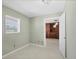 Bright bedroom featuring neutral walls, a window with blinds, and an open doorway to a bonus area at 150 Crestview Dr, Englewood, FL 34223