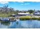 Exterior of a waterfront home with a private dock, boat lift, screened pool, and outdoor pergola at 150 Crestview Dr, Englewood, FL 34223