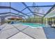 Screened-in pool area featuring a tiki bar with a charming tropical ambiance, perfect for relaxation at 150 Crestview Dr, Englewood, FL 34223