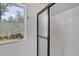 Modern bathroom shower stall enclosed with glass, complimented by a bright window view of the outdoors at 150 Crestview Dr, Englewood, FL 34223