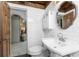 Bathroom with wood trim, white subway tile, pedestal sink, and toilet with view into another room at 1530 Philip Pl, Englewood, FL 34223