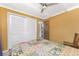 Bedroom with yellow walls, white ceiling and floor tiles plus bed, closet, and door to bathroom at 1530 Philip Pl, Englewood, FL 34223