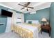 Bedroom with blue walls, white ceiling, white curtains, wall-mounted AC and TV and yellow floral comforter at 1530 Philip Pl, Englewood, FL 34223