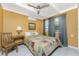 Bedroom with yellow walls, white ceiling and floor tiles plus bed, table, lamp, and AC unit at 1530 Philip Pl, Englewood, FL 34223