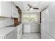 Bright and modern kitchen featuring white appliances, stylish backsplash, ample counter space, and a sunlit window at 1530 Philip Pl, Englewood, FL 34223