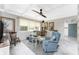 Inviting living room with vaulted ceilings, a ceiling fan, cozy seating, and an abundance of natural light at 1530 Philip Pl, Englewood, FL 34223