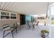 Inviting covered patio area with chairs and tables, perfect for relaxing outdoors at 1530 Philip Pl, Englewood, FL 34223