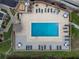 Aerial view of a community pool surrounded by lounge chairs and tropical landscaping at 1551 Beach Rd # 207, Englewood, FL 34223