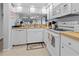 A clean, bright kitchen with white appliances and warm wood countertops at 1551 Beach Rd # 207, Englewood, FL 34223