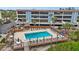 Aerial view of community pool with lounge seating and tables outside updated condos at 1551 Beach Rd # 207, Englewood, FL 34223