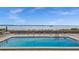 Outdoor pool with a waterfront view, lounge chairs, and a ladder for easy access at 1551 Beach Rd # 207, Englewood, FL 34223