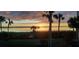 Waterfront view with palm trees creating a relaxing tropical scene at sunset at 1551 Beach Rd # 207, Englewood, FL 34223