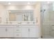 Modern bathroom with double sinks, quartz countertop, a large mirror, and a glass-enclosed shower at 17505 Opal Sand Dr # 101, Venice, FL 34293