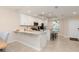 Kitchen features white cabinets, stainless appliances, breakfast bar, tile flooring, and modern lighting at 17505 Opal Sand Dr # 101, Venice, FL 34293