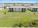 Expansive aerial view of the modern townhome buildings surrounded by lush greenery and open spaces at 17685 Boracay Ct # 202, Venice, FL 34293
