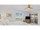 Comfortable bedroom with balcony access offering scenic views, complemented by a modern ceiling fan at 17685 Boracay Ct # 202, Venice, FL 34293