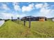 Fenced backyard featuring lush grass and showcasing the screened pool area, adding privacy and tranquility at 18 Annapolis Ln, Rotonda West, FL 33947