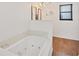 Bathroom features a white soaking tub and hardwood-look flooring at 18 Annapolis Ln, Rotonda West, FL 33947