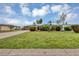 Manicured front lawn of a charming home with vibrant tropical landscaping and a circular driveway at 18 Annapolis Ln, Rotonda West, FL 33947