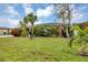 Home exterior featuring a green lawn and lush tropical landscaping at 18 Annapolis Ln, Rotonda West, FL 33947