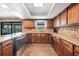 Charming kitchen features stainless steel appliances, granite countertops, wood cabinets and a view to the backyard at 18 Annapolis Ln, Rotonda West, FL 33947