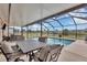 Inviting screened pool area with table and seating is perfect for outdoor dining and entertaining by the water at 18 Annapolis Ln, Rotonda West, FL 33947