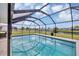 A screened-in swimming pool offers a refreshing oasis with clear blue water reflecting the sunny sky above at 18 Annapolis Ln, Rotonda West, FL 33947