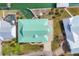 Aerial view of a home with a green roof, dock, pool, and well-manicured landscaping at 1905 Mississippi Ave, Englewood, FL 34224