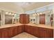 Bathroom with expansive double vanity, warm lighting and dual mirrors reflecting the shower at 1905 Mississippi Ave, Englewood, FL 34224