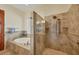 Bathroom with jetted tub, glass enclosed shower, and stylish neutral-colored tile at 1905 Mississippi Ave, Englewood, FL 34224